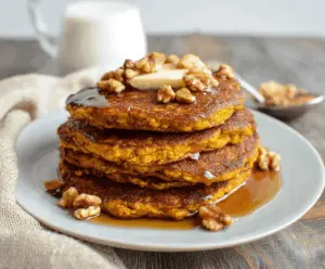 Creamy blender pumpkin oatmeal pancakes topped with fresh fruit and maple syrup, perfect for a healthy breakfast